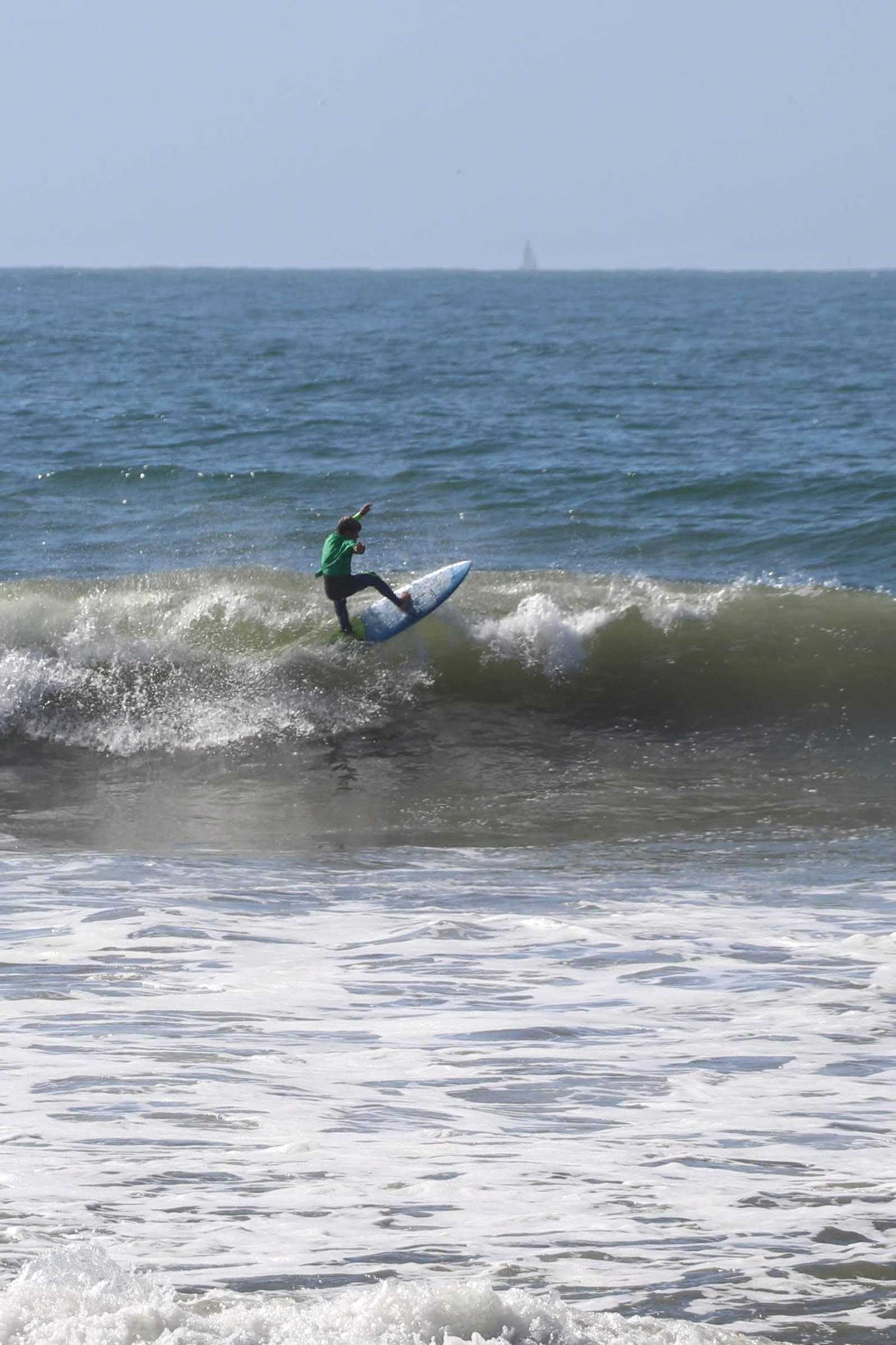 Surfer in green hitting the lip at the start of the heat. Credit: Olivia Sanford / The Foothill Dragon Press
