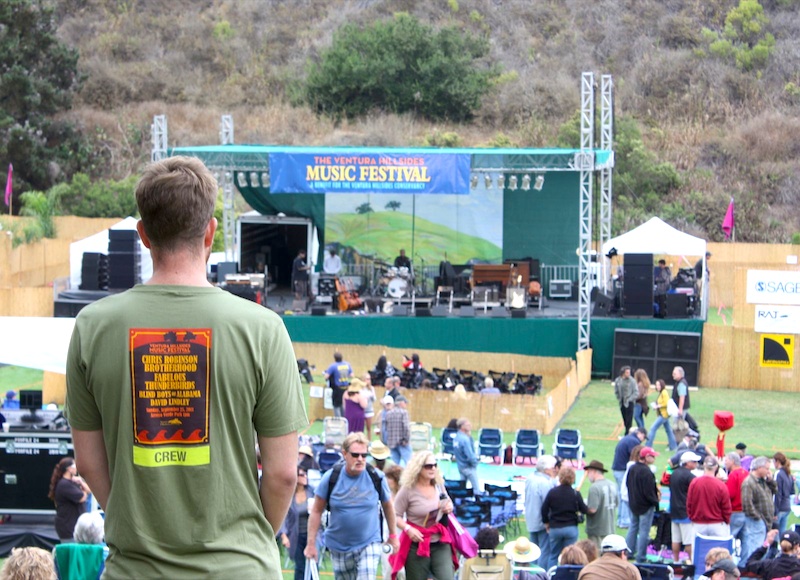 A crew member overlooks people gathering at the Hillsides Music Festival on Sunday. Credit: Megan Kearney/The Foothill Dragon Press.