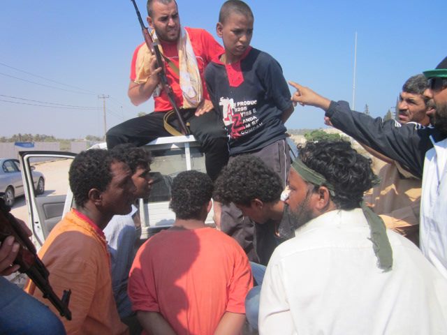 Suspected Gaddafi mercenaries, including a 14-year-old boy, are captured by revolutionaries on the road to Tripoli, Libya. Photo by Zeina Khodr. Used with permission.