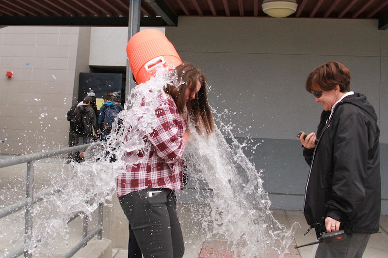 Editor-in-Chief, Rachel Crane, gets doused with water, a tradition started three years ago when the Dragon press won its first Pacemaker. Credit: Aysen Tan/ The Foothill Dragon Press