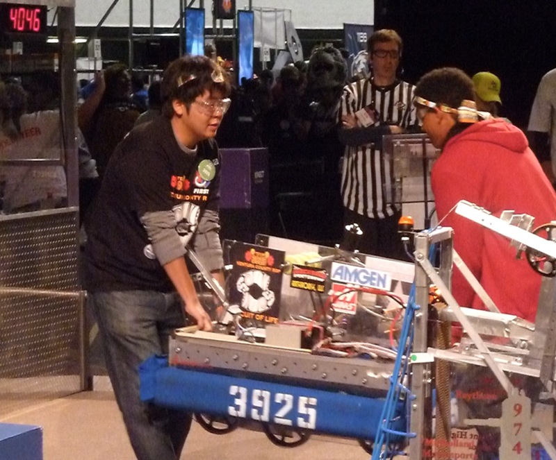 Foothill students and Circuit of Life members Jongseung Baek (left) and Jordan Brown (right) carry the team's winning robot at the Los Angeles FIRST Robotics Competition. Credit: Brandon Longo. Used with permission.