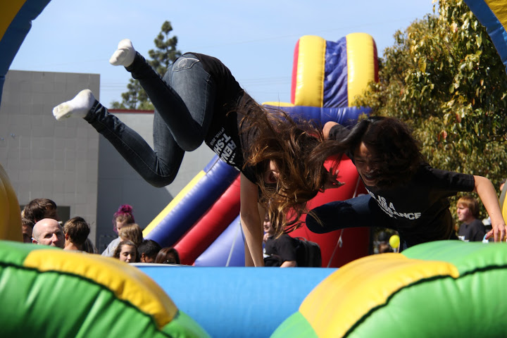 Sophomores Joceyln Carrol and Michelle Pablo race on the inflatable obstacle course at Friday's Renaissance rally. Credit: Josh Ren/The Foothill Dragon Press
