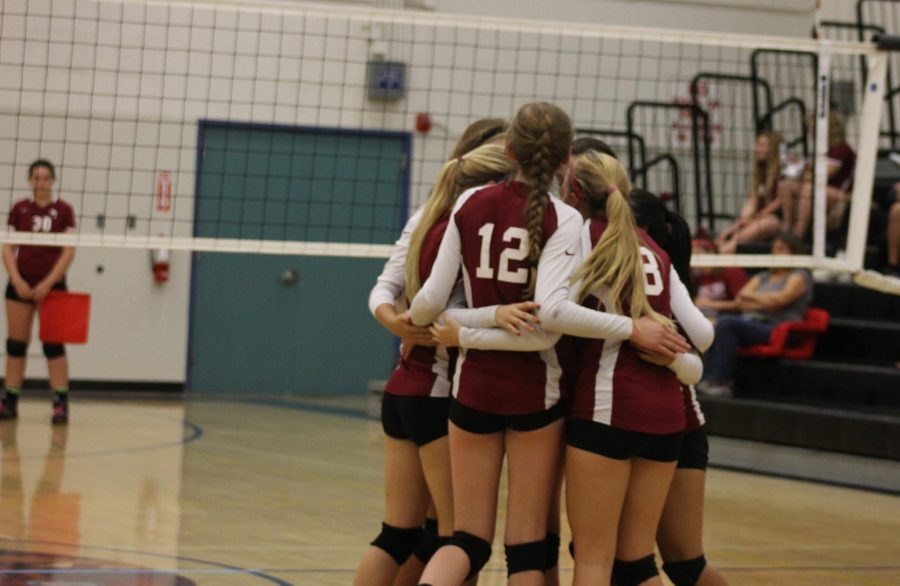 The Foothill varsity girls volleyball team hugging at their game, October 30, 2014. Credit: Elizabeth Anthony/The Foothill Dragon Press 