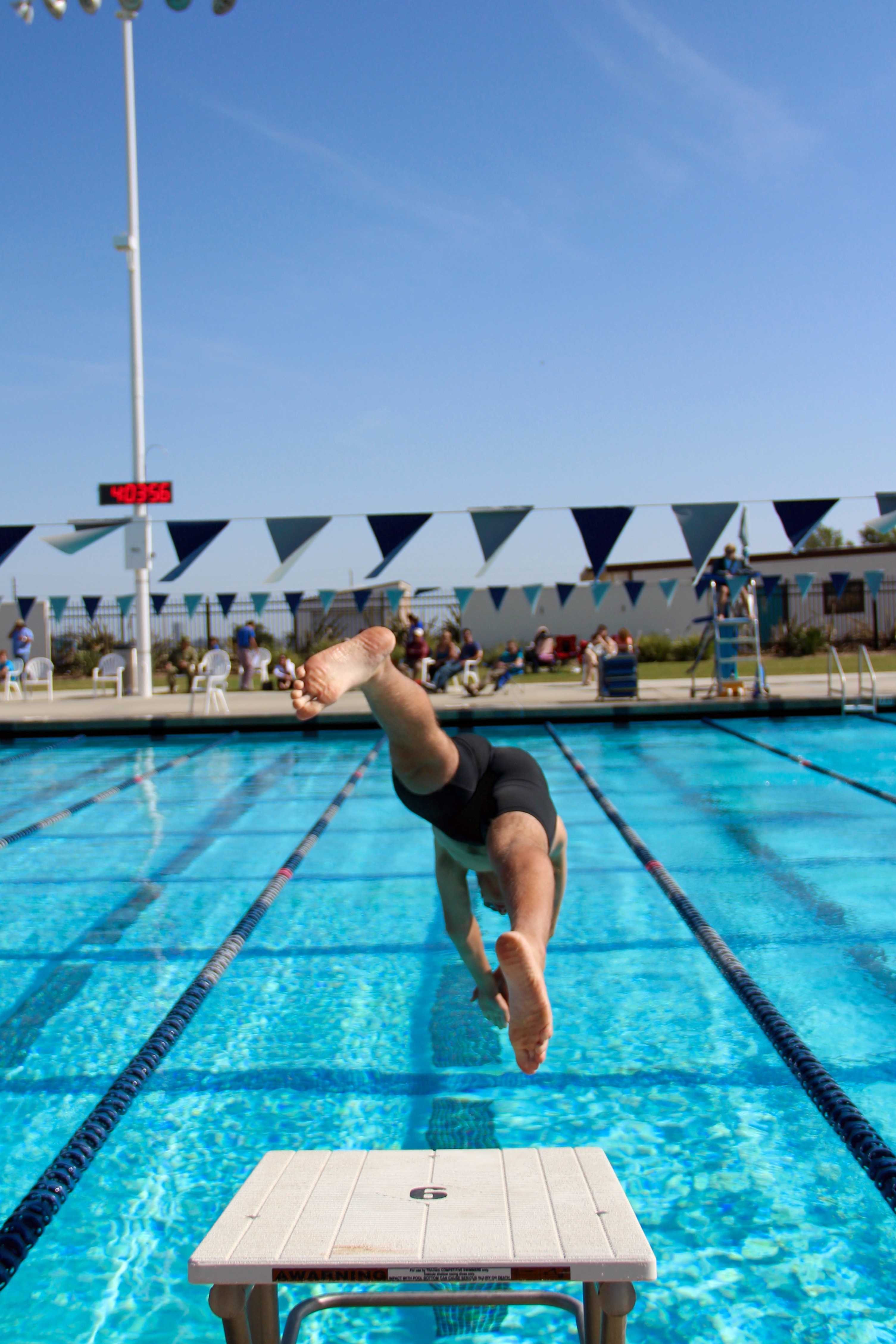 A swimmer jumps into the pool, ready to compete. Credit: Kazu Koba/The Foothill Dragon Press