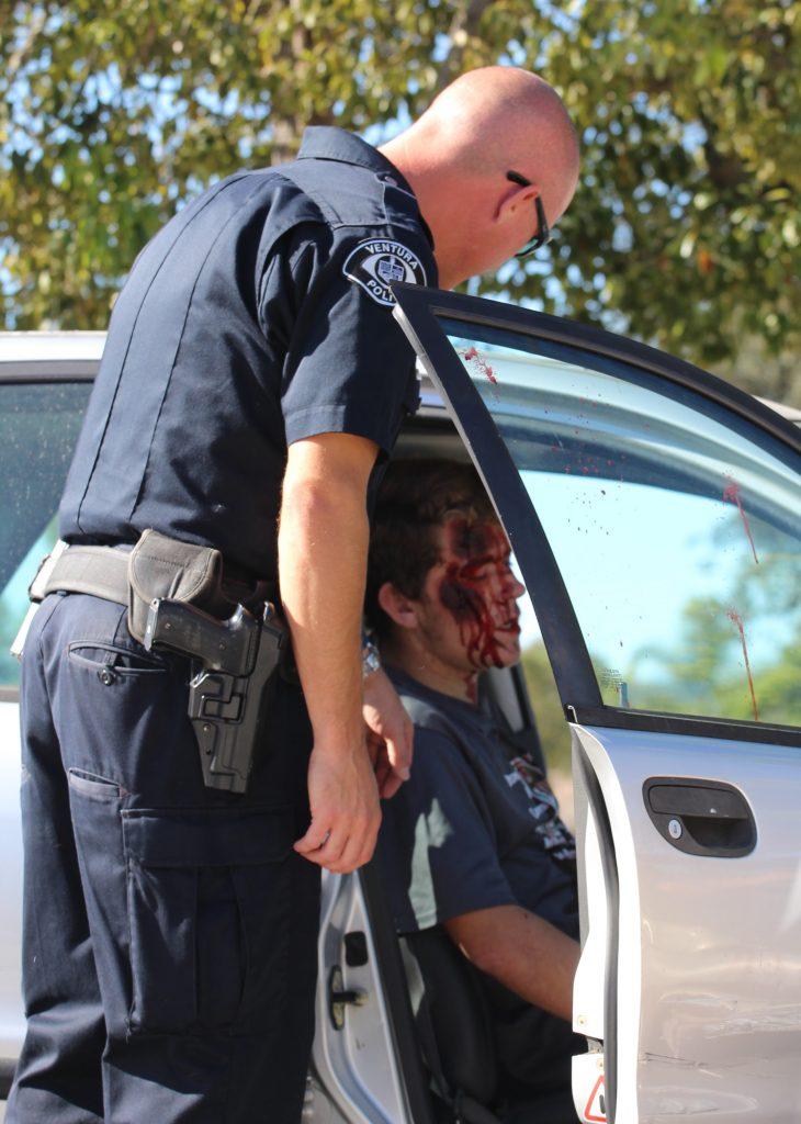 A police officer assesses Kevin Waechter's situation and how best to act by asking him questions in the typical emergency procedure. Credit: Carrie Coonan/The Foothill Dragon Press