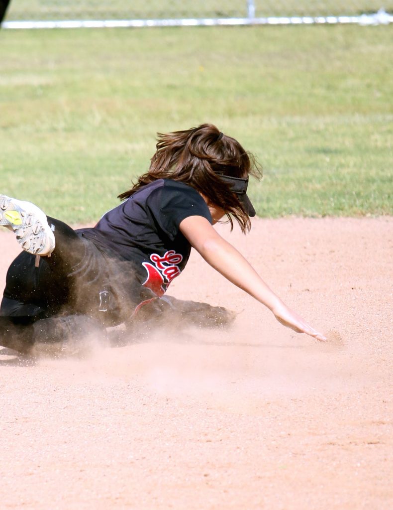A player from Grace Brethren slides in an attempt to reach the ball.