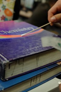 BioScience survey student swabs bacteria colony off chemistry textbook. Credit: Jason Messner / The Foothill Dragon Press