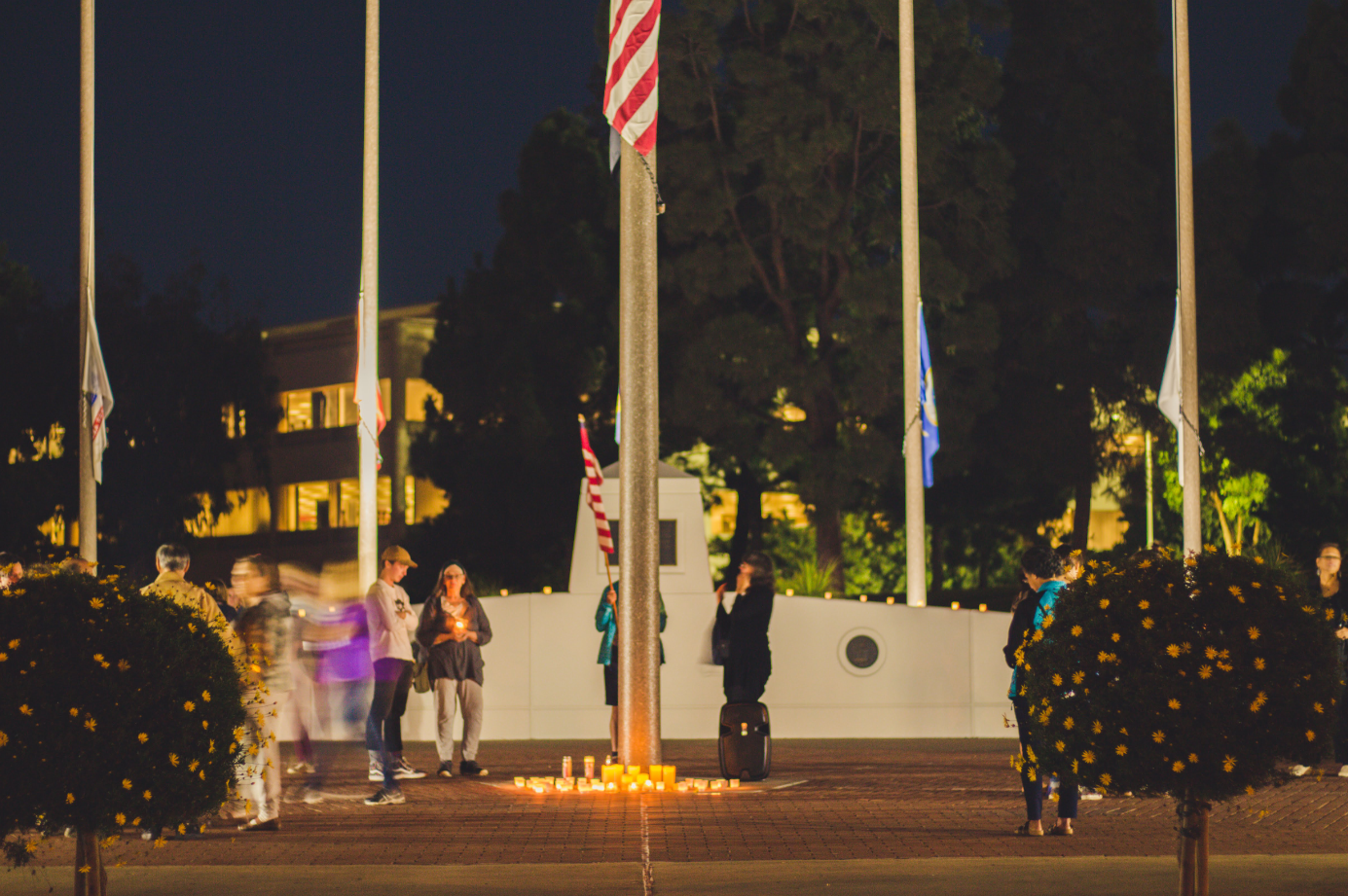 Behind the vigil, each flag hung at the government center is at half mast as a mark of respect towards each Borderline Bar & Grill shooting victim. Credit: Stefan Fahr / The Foothill Dragon Press