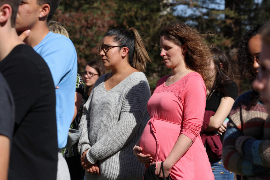 Expecting mother holds her palm over her unborn child, as she thinks of other parents who have lost their own to this tragedy. Credit: Olivia Sanford / The Foothill Dragon Press