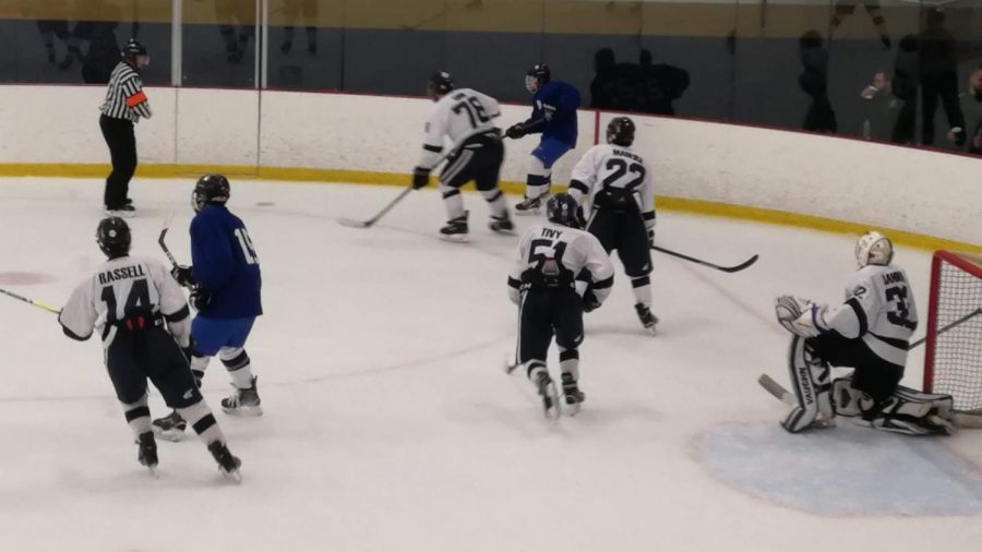 Nick Tivy 22 skates by the goalie, ready to shut down a pass across the ice. 