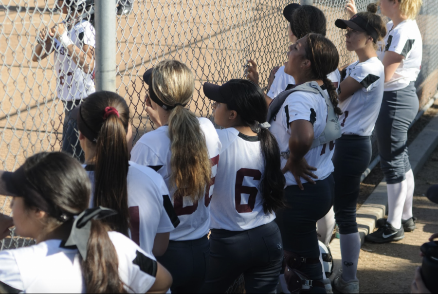 Players watch and support their teammate as they get ready to bat.