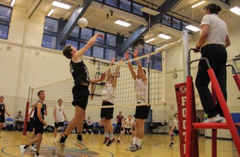 Stefan Fahr 19 and Logan Grenier 19 reach up to block the incoming ball.