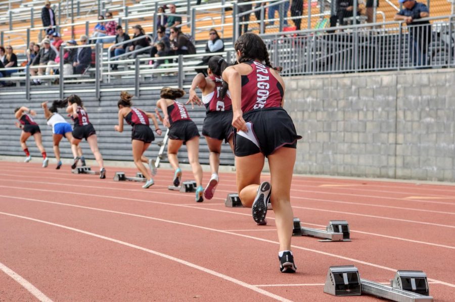 After the gun sounds, sprinters rush from their blocks.