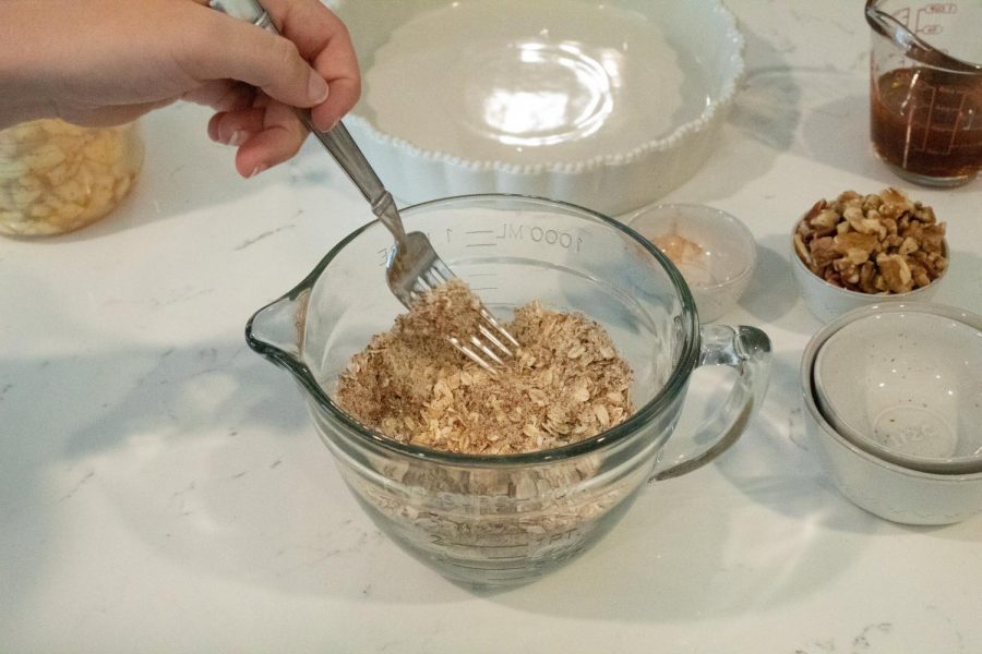 To make the crust, mix 1 cup of old fashioned oats, ½ cup of nuts chopped (preferably walnuts and pecans), ½ cup of almond meal, ½ teaspoon of salt, ½ teaspoon cinnamon and ½ teaspoon of pumpkin pie spice into a bowl