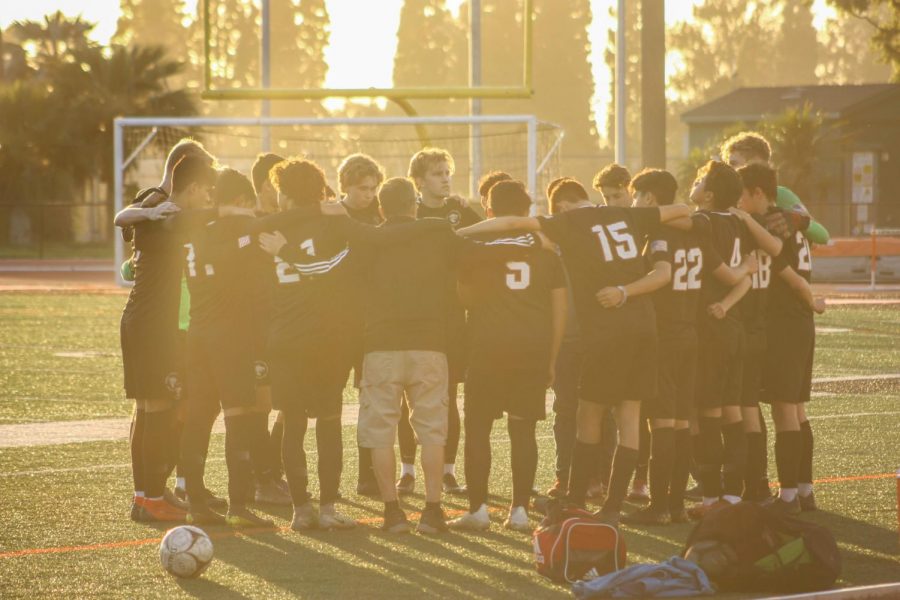 Boys Soccer team gathers with Coach Rick Villano before the game.