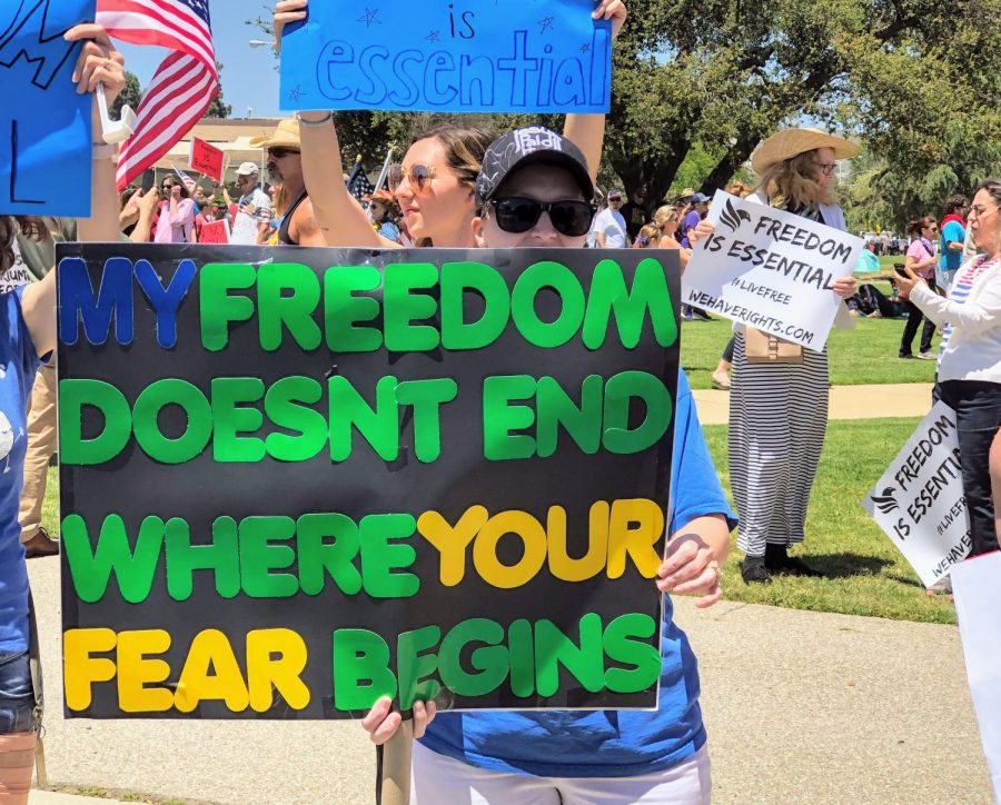 A woman participating in the protest holds a sign that states, My freedom doesnt end where your fear begins.