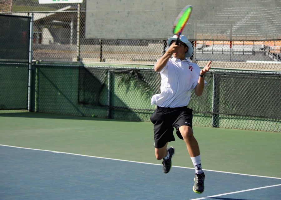 Ethan Wang '20 jumps in his forehand swing.