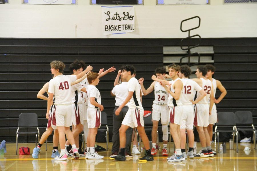 The boys basketball team rallies together in one of their last few season huddles.