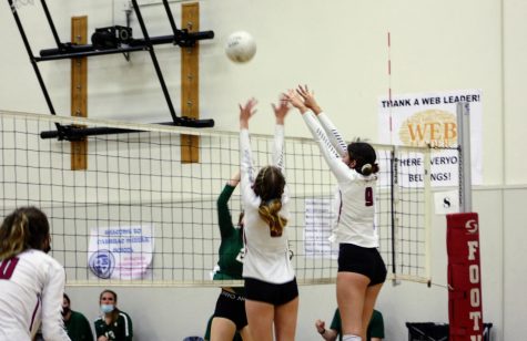 Maliah Juker 22 and Aimee Kidwell 22 block a spike from the opposing team and score a point.