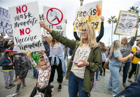 Parents rally with posters and chants in Huntington Beach to protest the public school vaccine mandate.