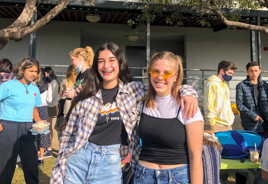 Natalie Schermer '24 and Moia Kingsley '24 pose in their 90's gear accented by flame glasses and chain belts.