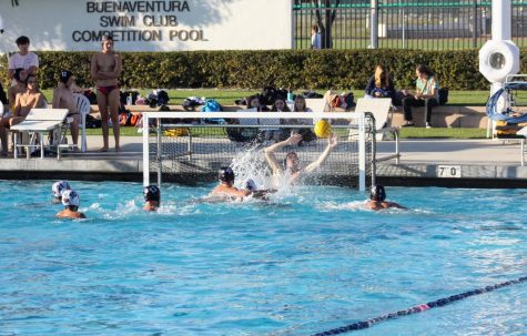 Ben Zeko 22 lunges out of the water to block the opponents shot.