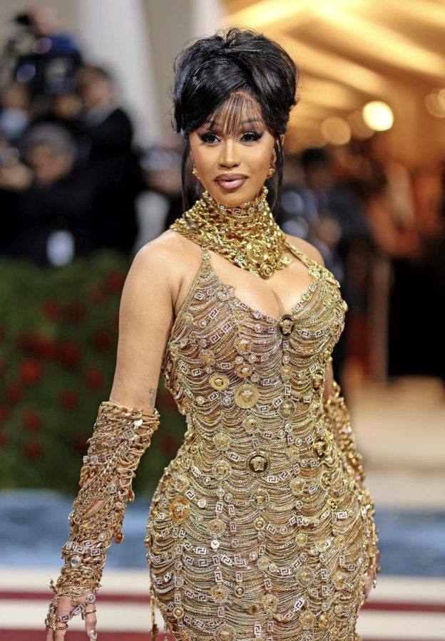 Cardi B enters the Met Gala with a dress made up of gold chains and jewelry.