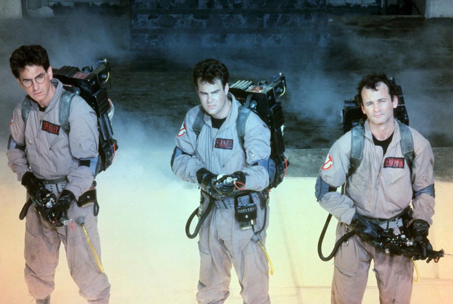 The three Ghostbusters stand, point their weapons, and anxiously await the arrival of paranormal activity. 