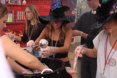 Wearing colorful witches hats, members of ASB pour out a spooky yet delicious concoction called Witches Brew.