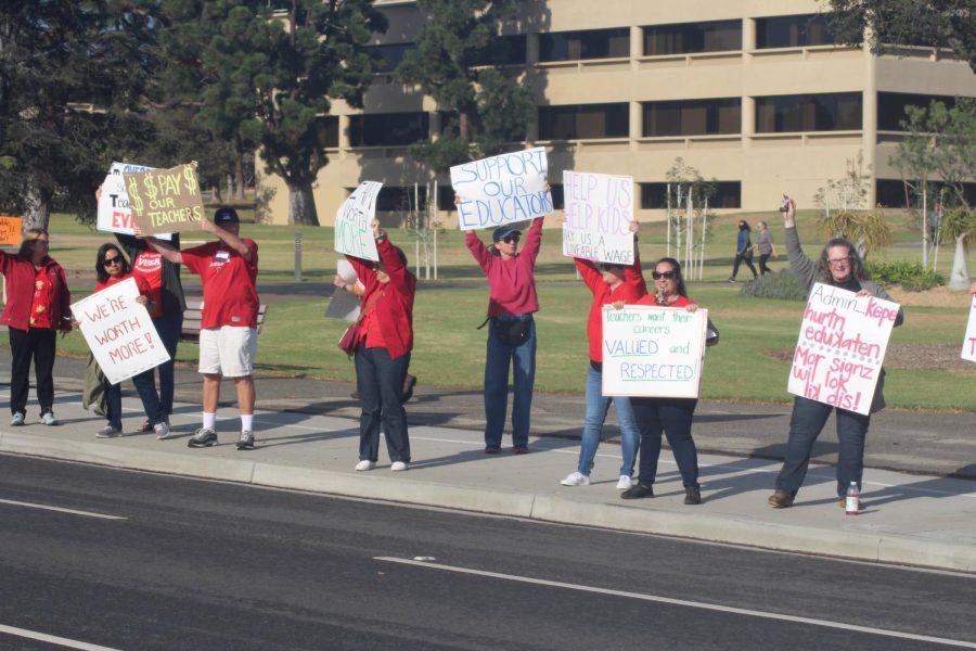 Ventura Unified educators wave at cars and hold up signs to bring attention to their recent attempts to increase teacher salaries district wide. 