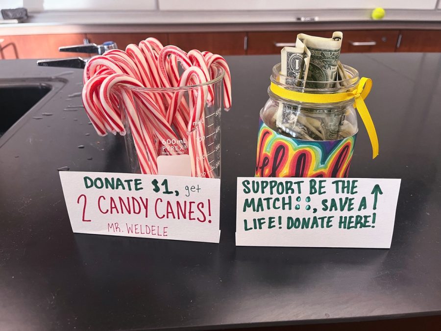 On+the+week+of+Dec.+5%2C+2022%2C+the+Bioscience+Academy+showcases+their+Be+The+Match+fundraiser+to+help+save+the+lives+of+those+with+cancer.+Donation+jars%2C+wrapped+in+colorful+designs%2C+overflow+with+dollar+bills+as+students+buy+candy+cane+after+candy+cane.+