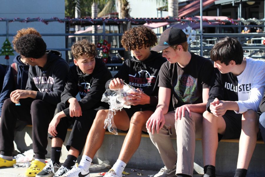 Moments before the lunch break is over, a group of six freshman attempt to unwrap a ball of plastic filled with candies. The treats fall onto the ground as they pass it on to their teammates and time runs down.