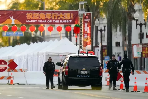 Security stands outside of the Monterey Park festival after its cancellation due to the shooting that occurred the day before. The banner reads “Happy Year Of The Rabbit,” although the situation is far from happy.