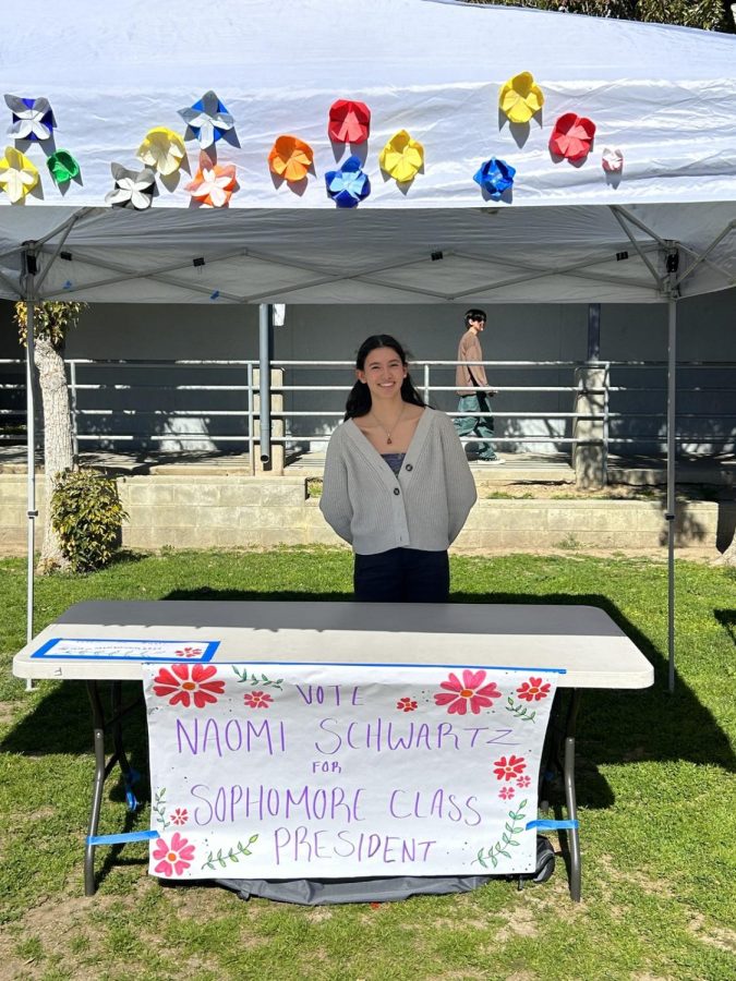 Naomi Schwartz 26 invites students to her flowery booth as she promotes her candidacy for sophomore class president on Feb. 8, 2023. 