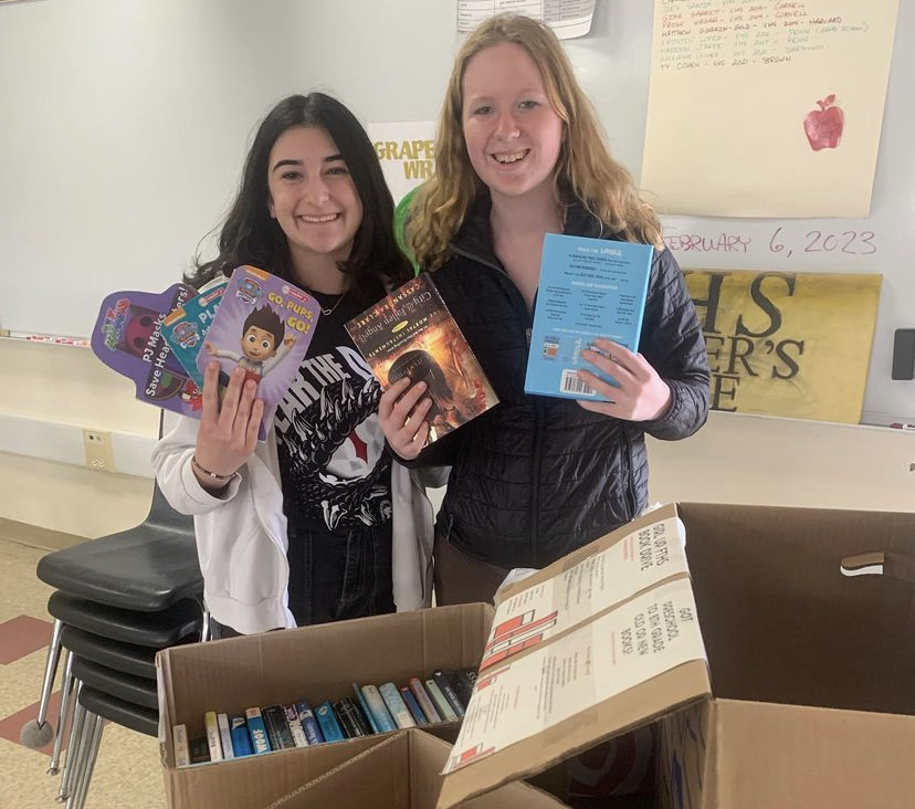 Girl Up club leaders Natalie Schermer 24 and Claire Hadley 24 count the total number of books donated to the book drive.