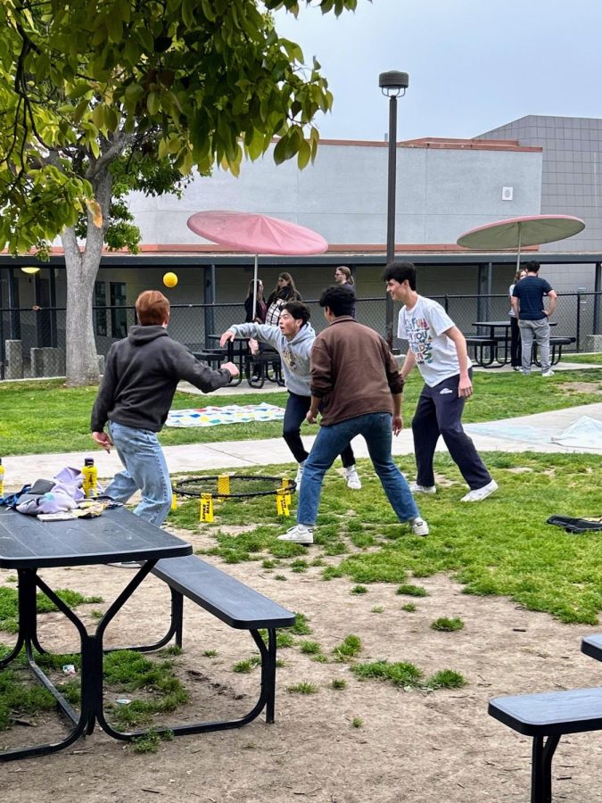 Laughter fills the air as a group of seniors play a very competitive game of spike ball in the middle of the quad.