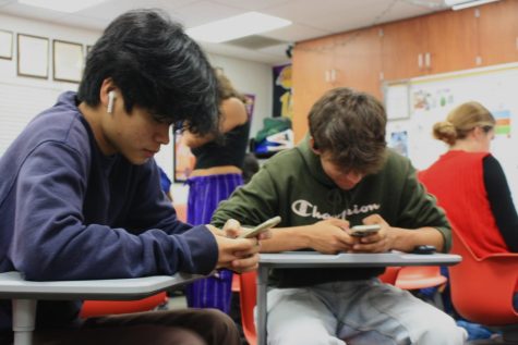 Two students endlessly scroll on their phones during class. Foothill Techs long-standing policy dictates that teachers are allowed to confiscate phones if deemed an interruption to class time.