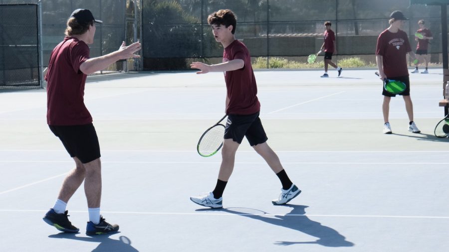 Pascal Hayward '23 and James Sokoloski '24 go in for a high-five after winning a volley.