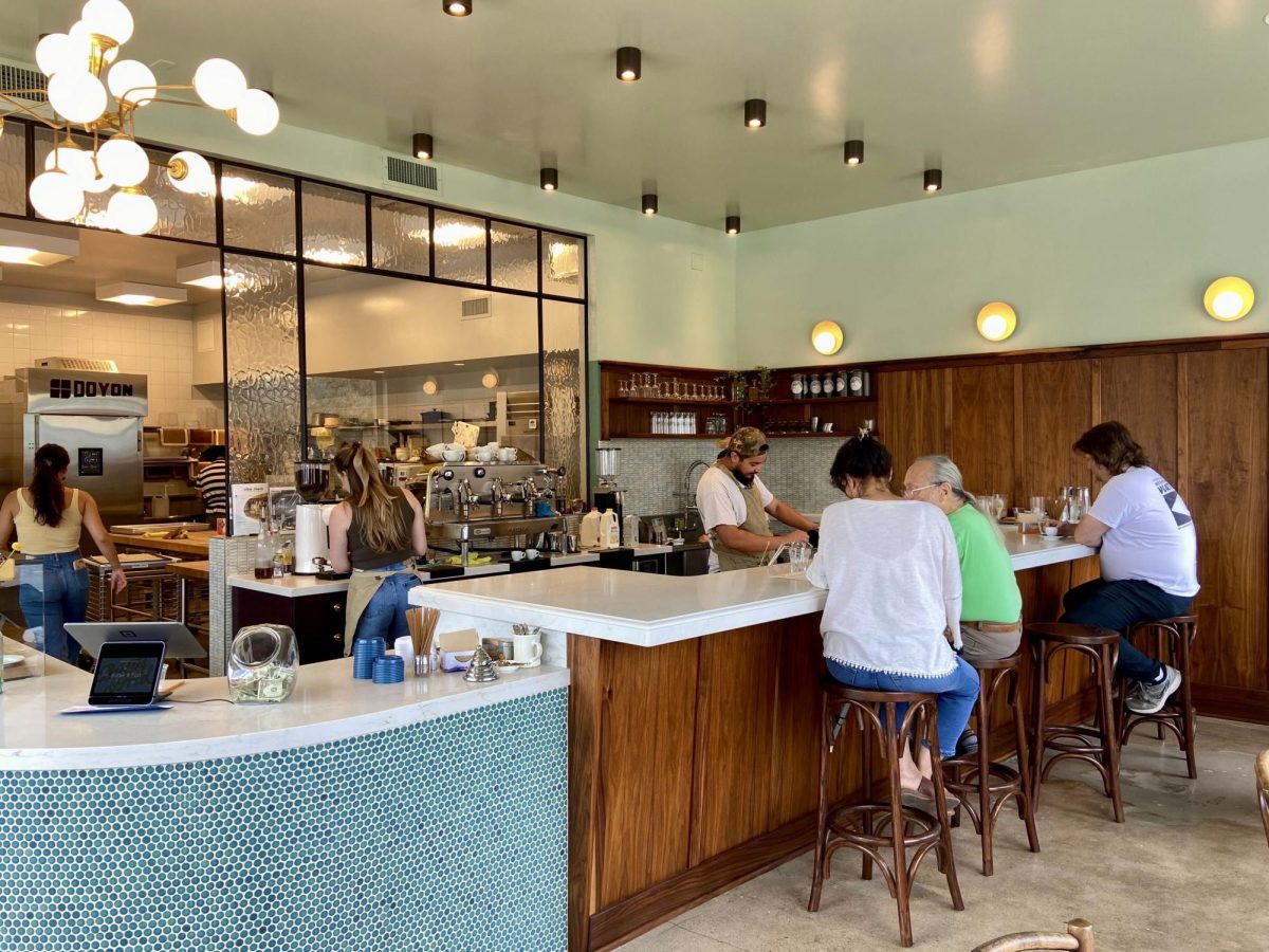 The interior of Butter and Fold has a stylish yet warm atmosphere, demonstrating the cafes elegance and charm. Customers are seen conversing over beverages while employees happily work with a smile on their faces.