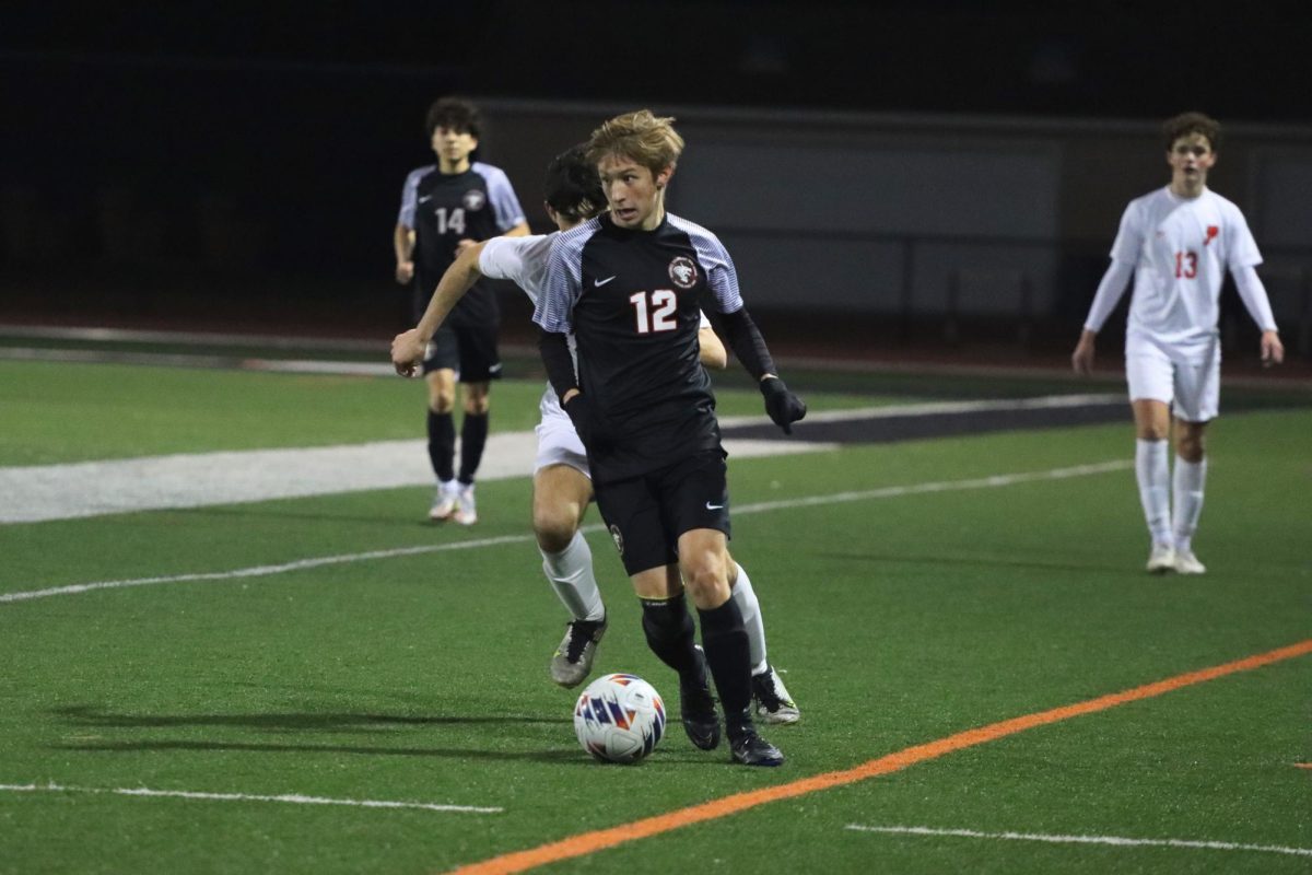 Nathan Leedy ‘24 (number 12) dribbles after a defensive stop, looking for an open teammate on the other side of the field. Leedy had an strong defensive game for the Dragons breaking the rhythm of the Panther’s offensive on various occasions.