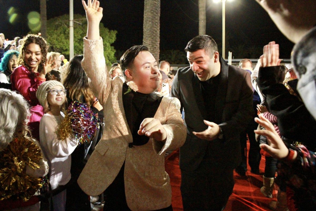 March 8, 2024, marked the return of the well-known and highly-anticipated event: Night to Remember. Held at Ventura County Fairgrounds, Night to Remember served as a way for people to connect with those around them, while honoring those with disabilities. In this photo, one of the many guests walks down the red carpet waving at those around him, while his host enthusiastically helps him toward San Miguel Hall.