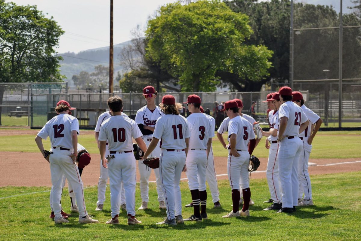 Foothill Technology High School’s starting lineup heads out to the field to warm up for the start of the first inning. The team talks strategy to prepare for their league game against Grace Brethren High School.