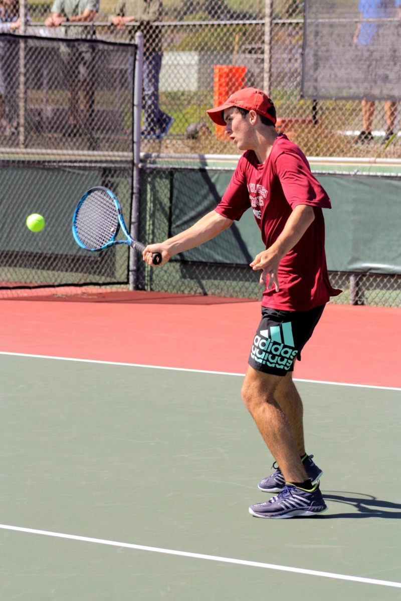Charlie Powers 27 approaches the net with a volley. Powers has been a dominant force on the tennis team this year, in his first year of high school tennis he has claimed the number one singles spot.