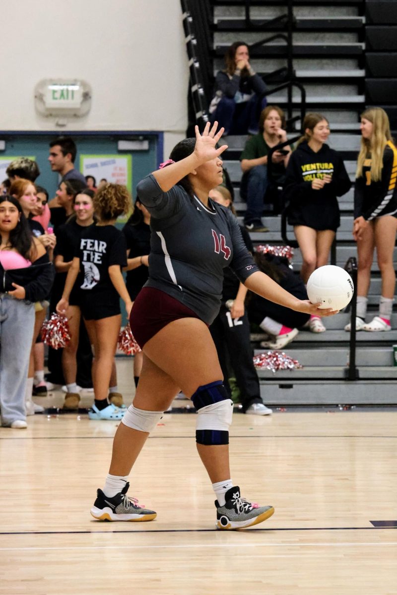 Channing McClure '25 (number 14) prepares to serve the ball in motion with unwavering focus. McClure serves the ball to Bonnie and continues to show her technique and control.The energy and skill that McClure brings to the game showcases her drive and dedication to her team, being one of the team captains.