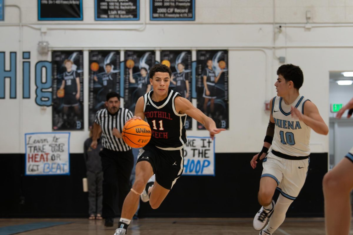 With a win against Santa Clara on Friday Dec. 6, the Foothill Technology High School (Foothill Tech) boys basketball team traveled to Buena High School to battle the Bulldogs in a nail-biting game. Although the Dragons were up by three at halftime, the Bulldogs fought back and won, with the final score of 54-61. Pictured, Ashton Brown '26 (number 11), takes the ball down the court using his handles to out-maneuver his defender. Brown was one of the key components of the game from his efforts on offense, ranging from three-pointers to ball movement, to his intense defense that resulted in multiple blocks and steals.