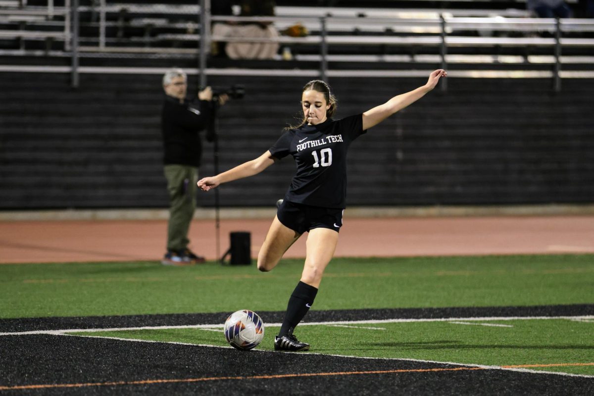 Siena Meter '26 kicks the ball toward the goal with determination, her eyes fixed on the ball as her defenders try to scramble to block her path. With a swift move she takes, aiming to score in a tense moment of the match.