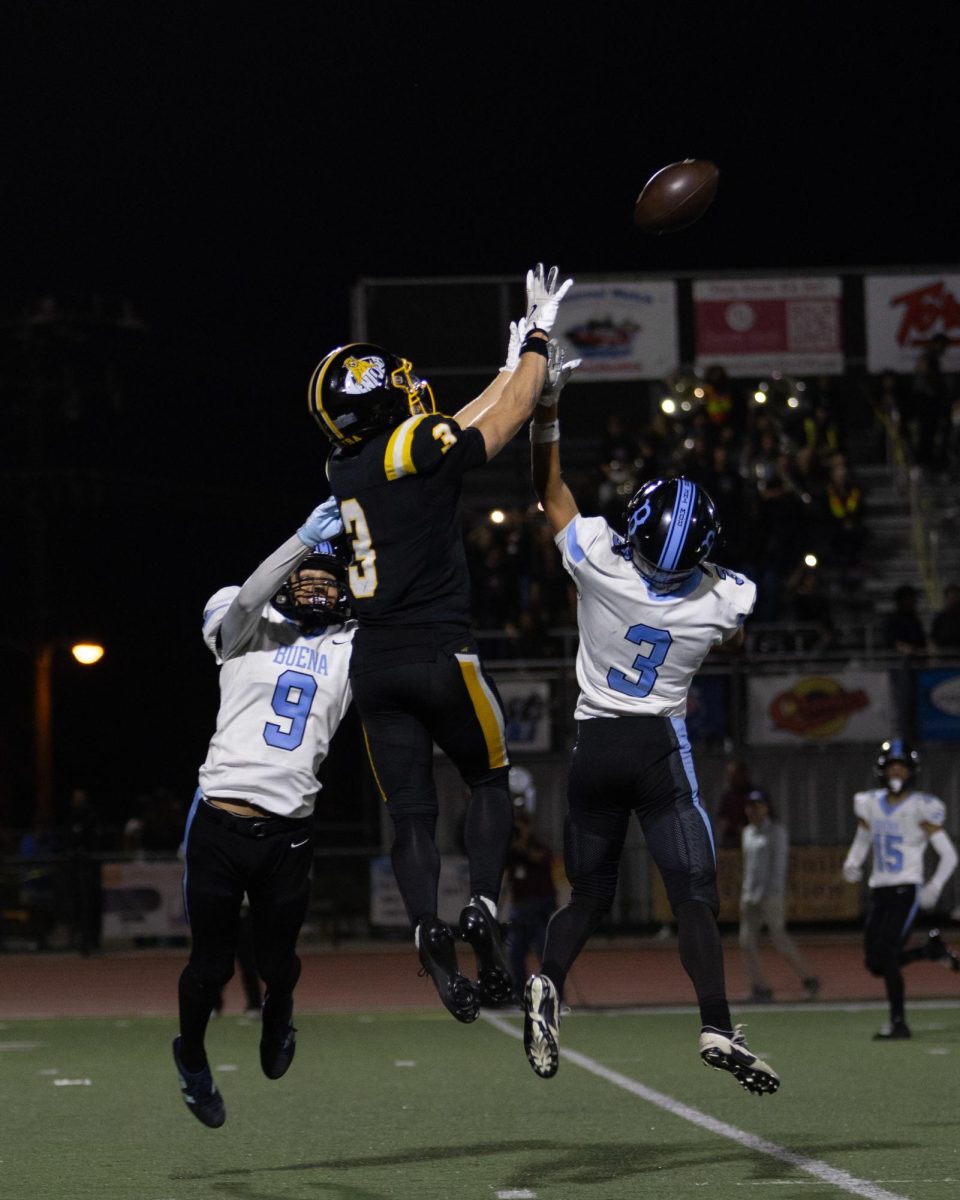 On the night of Oct. 3, 2025, Buena High School (Buena) and Ventura High School (Ventura) clashed in their annual rivalry game under the lights. Both teams battled with intensity and pride, but Ventura’s dominant performance on both sides of the ball led to a decisive 62-13 victory, continuing their strong season and school tradition. Pictured here, is Jack Cunningham ’26 (number 3) leaps up in the air reaching for the ball over two buena defenders.