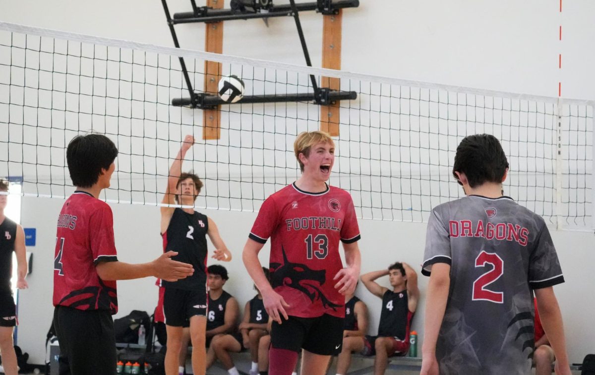 On the night of March 19, 2026, the Foothill Technology High School boys volleyball team battled Bishop Diego. Despite the loss of 0-3, the Dragons battled with multiple rallies and strong swings at the net. Curren Wiggins '26 (number 13) celebrates with his teammate, Zach Ohl '28 (number 2), after a long rally and kill.