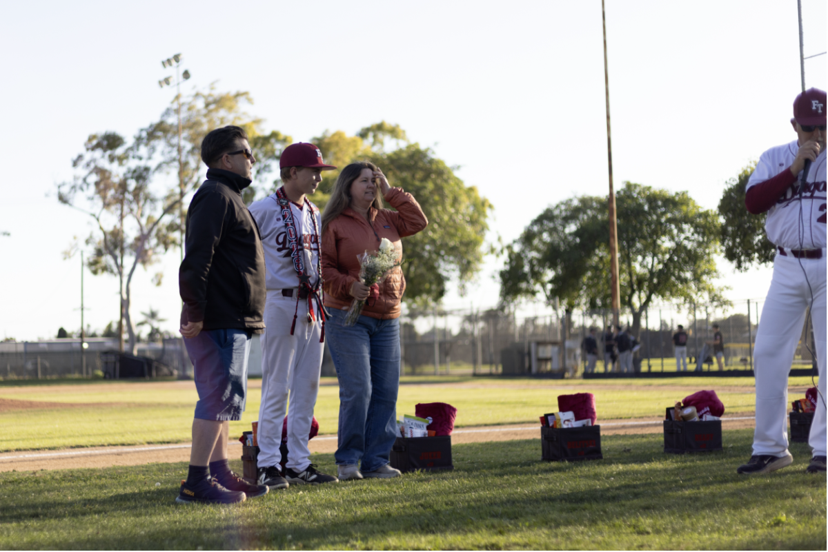 Garret Ready '26 listened as head coach Mike Haas spoke about him after the game during Foothill Technology High School’s baseball senior night.