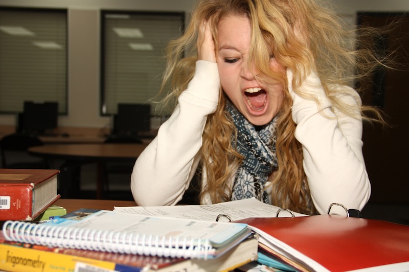 Junior Emily Coe poses as a stressed student studying for finals. Photo illustration: Felicia Perez/The Foothill Dragon Press